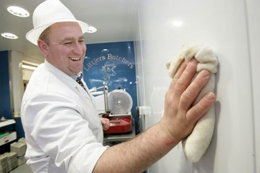 A chef cleaning Altro Whiterock White with a cloth.