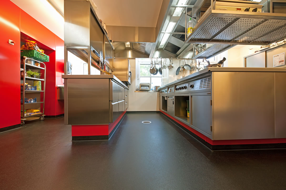 Altro whiterock Satins in a red shade and Altro Stronghold in a brown shade in a commercial kitchen