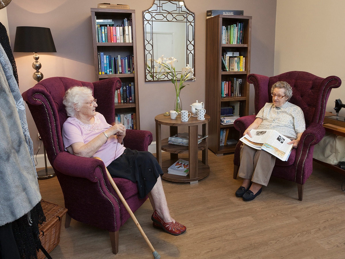 Two elderly ladies sitting in a living area at Norse Care at Westfields Care Home with Altro Wood Safety installed on the floor
